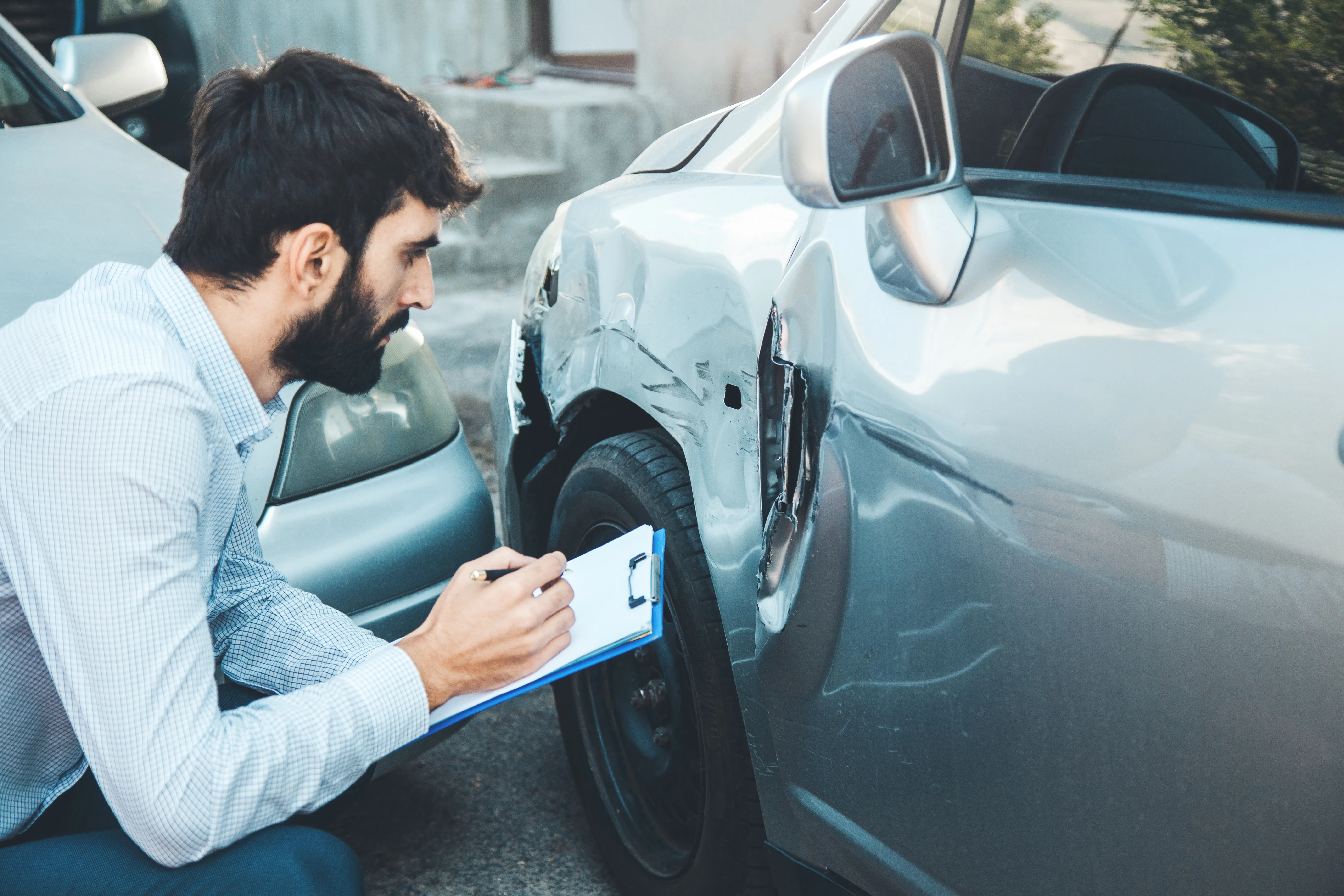 an investigator looking at a damaged car